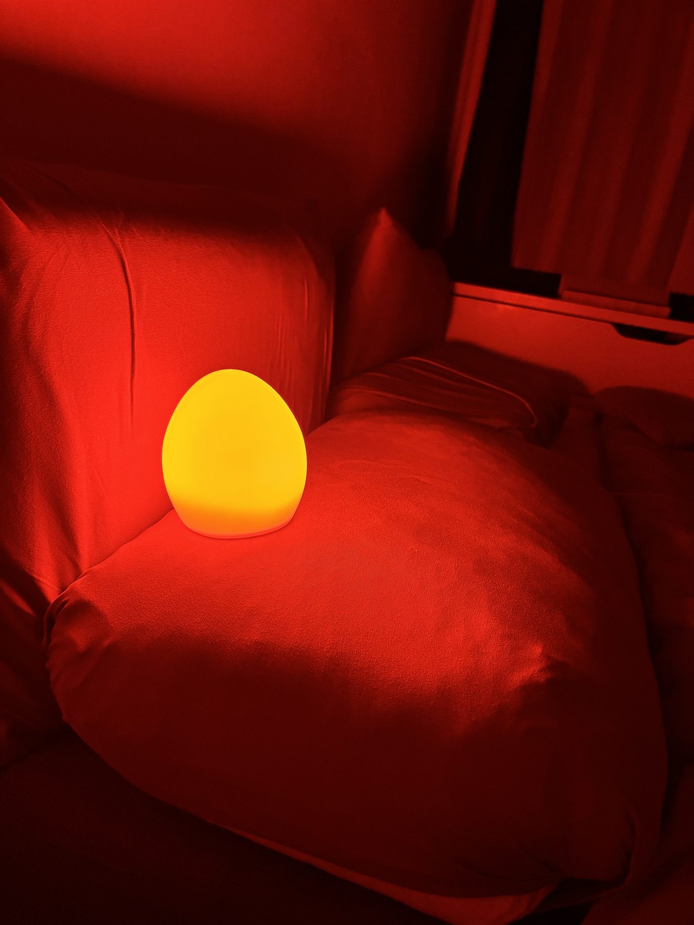 Owlnest Lume glowing in a dark bedroom setting